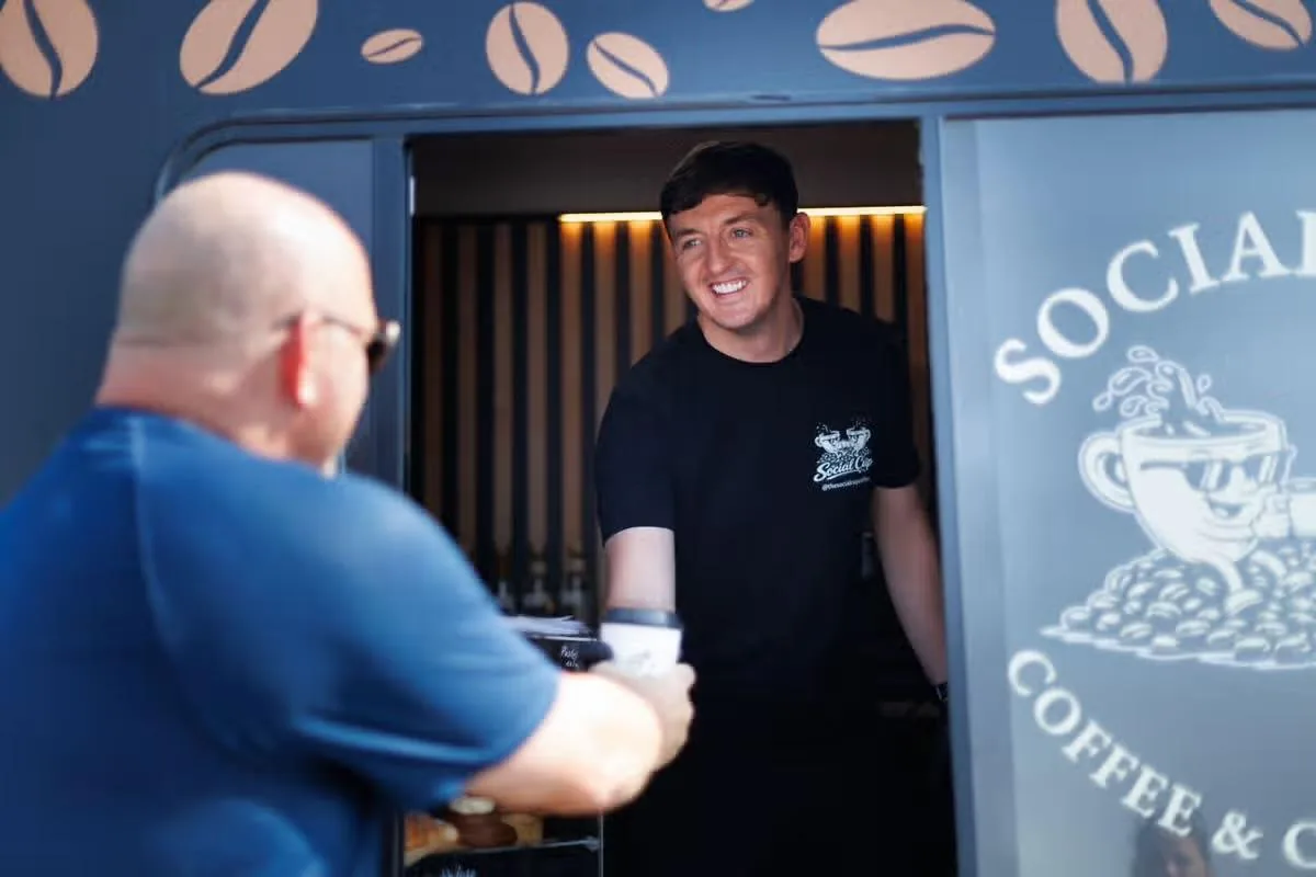 Connor Doyle serving a customer at the hatch of the Social Cup van